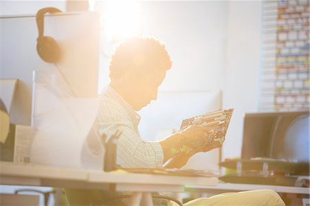 soft focus creative - Businessman holding circuit board in sunny office Stock Photo - Premium Royalty-Free, Code: 6113-07147836