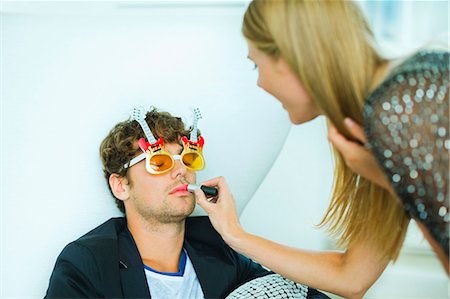 funny couples - Woman applying lipstick to sleeping man at party Stock Photo - Premium Royalty-Free, Code: 6113-07148078
