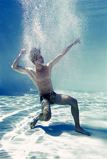 Man posing underwater in swimming pool Stock Photo - Premium Royalty-Free, Image code: 6113-07148081