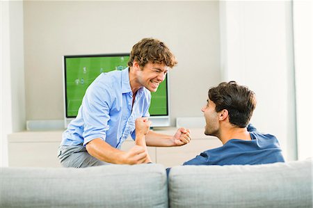 people watching football on tv - Men cheering and watching soccer game Stock Photo - Premium Royalty-Free, Code: 6113-07148014