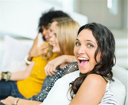 Enthusiastic woman on sofa with friends Stock Photo - Premium Royalty-Free, Code: 6113-07148024