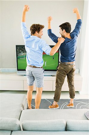 feet on sofa - Men cheering and watching soccer game Stock Photo - Premium Royalty-Free, Code: 6113-07148030