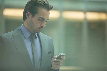 simsearch:6113-06908958,k - Businessman using cell phone in office Stock Photo - Premium Royalty-Free, Code: 6113-07158891