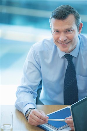 simsearch:6113-07242758,k - Businessman smiling at desk Stock Photo - Premium Royalty-Free, Code: 6113-07158974