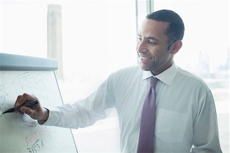 seminar smiling - Businessman writing on whiteboard in office Stock Photo - Premium Royalty-Free, Code: 6113-07158915