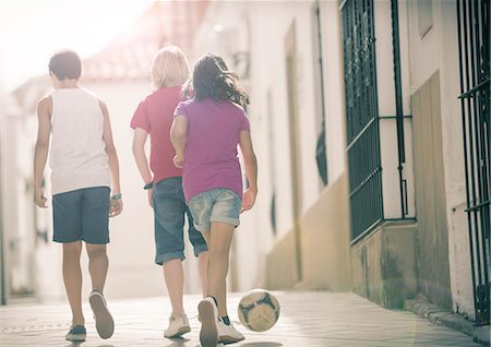 simsearch:6113-07159177,k - Children playing with soccer ball in alley Foto de stock - Royalty Free Premium, Número: 6113-07159158