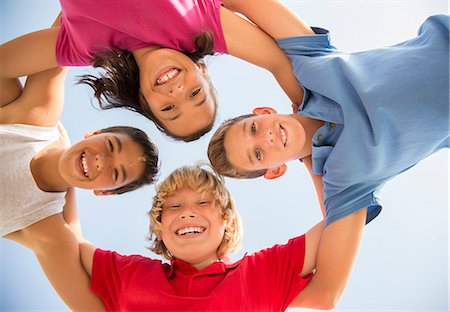 people in a huddle - Children smiling in huddle outdoors Stock Photo - Premium Royalty-Free, Code: 6113-07159178