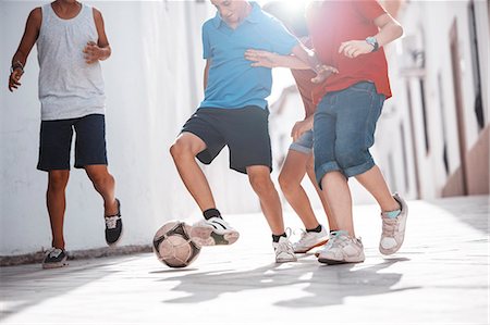 running teenage boy & girl - Children playing with soccer ball in alley Stock Photo - Premium Royalty-Free, Code: 6113-07159182