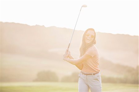 Woman playing golf on course Photographie de stock - Premium Libres de Droits, Code: 6113-07159198