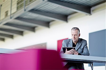 simsearch:6113-07160408,k - Businessman using digital tablet in lobby Stock Photo - Premium Royalty-Free, Code: 6113-07159108