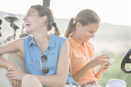 people laughing smart phones outdoor - Women sitting in golf cart Stock Photo - Premium Royalty-Free, Code: 6113-07159247