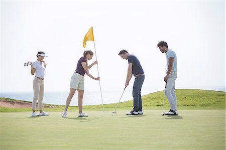 Friends putting on golf course Foto de stock - Sin royalties Premium, Código: 6113-07159263
