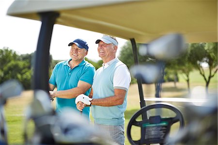 Senior men standing next to golf cart Stock Photo - Premium Royalty-Free, Code: 6113-07159269