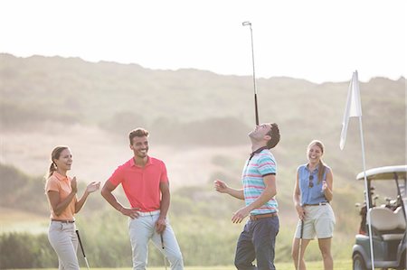 simsearch:6113-07159249,k - Friends watching man balance golf club on nose Photographie de stock - Premium Libres de Droits, Code: 6113-07159277