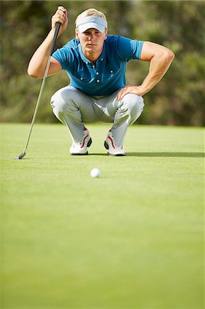 Man preparing to putt on golf course Stock Photo - Premium Royalty-Free, Code: 6113-07159215