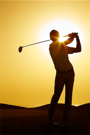 Silhouette of man swinging golf club Photographie de stock - Premium Libres de Droits, Code: 6113-07159233