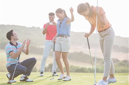 fahnenmast - Friends playing golf on course Photographie de stock - Premium Libres de Droits, Code: 6113-07159236