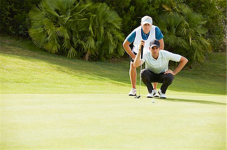 simsearch:6113-07159316,k - Caddy and golfer preparing to putt Stock Photo - Premium Royalty-Free, Code: 6113-07159316