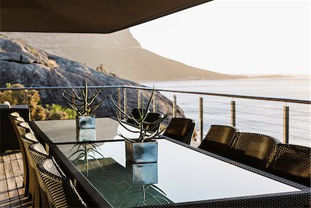 Dining table on luxury patio overlooking ocean Foto de stock - Sin royalties Premium, Código: 6113-07159457