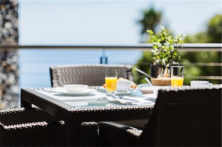 placesetting - Breakfast on luxury patio dining table overlooking ocean Stock Photo - Premium Royalty-Free, Code: 6113-07159459