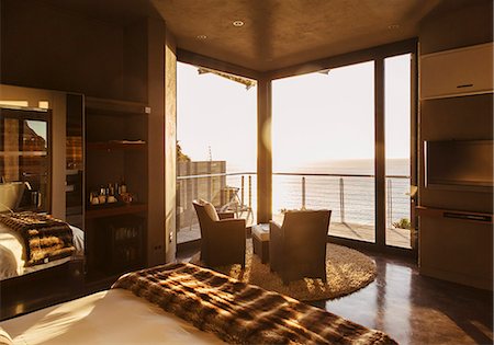 simsearch:6113-07159879,k - Luxury bedroom overlooking ocean at sunset Stock Photo - Premium Royalty-Free, Code: 6113-07159474