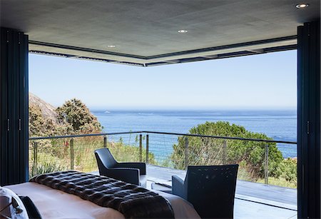 Luxury bedroom and balcony overlooking ocean Photographie de stock - Premium Libres de Droits, Code: 6113-07159475