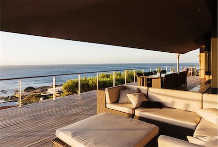 Sofa and table on luxury patio overlooking ocean Foto de stock - Sin royalties Premium, Código: 6113-07159478