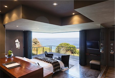 pieza - Modern bedroom overlooking ocean Foto de stock - Sin royalties Premium, Código: 6113-07159429