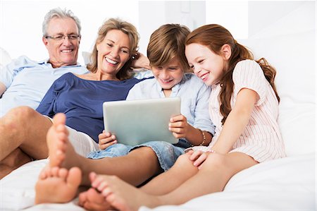 simsearch:6113-06626338,k - Older couple and grandchildren using digital tablet Stock Photo - Premium Royalty-Free, Code: 6113-07159588