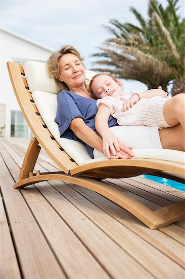 Older woman and granddaughter relaxing in lawn chair Stock Photo - Premium Royalty-Free, Image code: 6113-07159593