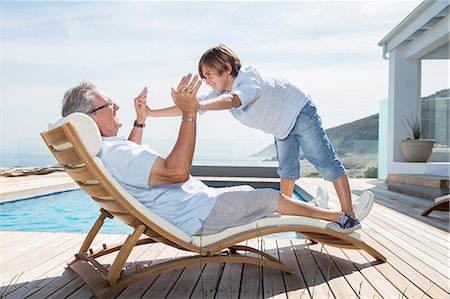 sundeck - Grandfather and grandson playing at poolside Stock Photo - Premium Royalty-Free, Code: 6113-07159507