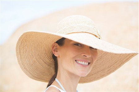 Woman wearing straw hat outdoors Photographie de stock - Premium Libres de Droits, Code: 6113-07159504