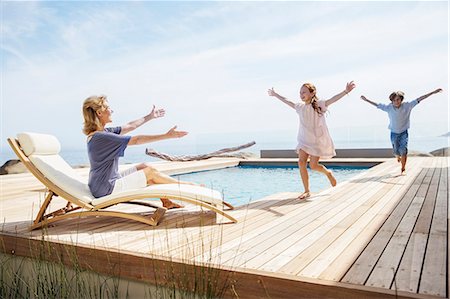 Children running to grandmother by pool Stock Photo - Premium Royalty-Free, Code: 6113-07159519