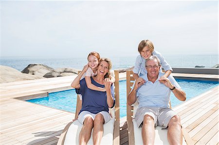 simsearch:6113-07159647,k - Grandchildren hugging grandparents at poolside Photographie de stock - Premium Libres de Droits, Code: 6113-07159525