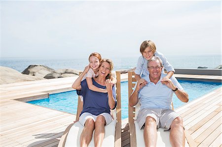 simsearch:6113-07159647,k - Grandchildren hugging grandparents at poolside Stock Photo - Premium Royalty-Free, Code: 6113-07159525