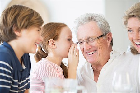 Girl whispering to grandfather at table Photographie de stock - Premium Libres de Droits, Code: 6113-07159657