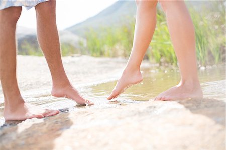 Couple dipping feet in rural pond Photographie de stock - Premium Libres de Droits, Code: 6113-07159664