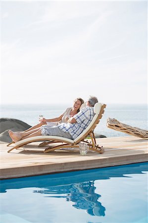 simsearch:6113-07159499,k - Older couple relaxing by pool Stock Photo - Premium Royalty-Free, Code: 6113-07159677