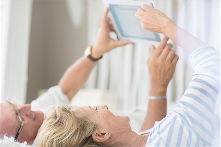 Older couple using digital tablet on bed Photographie de stock - Premium Libres de Droits, Code: 6113-07159621
