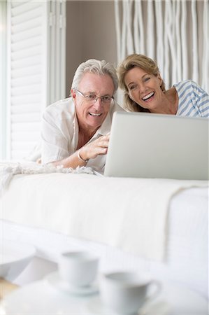 simsearch:6113-07146877,k - Older couple using laptop on bed Photographie de stock - Premium Libres de Droits, Code: 6113-07159625