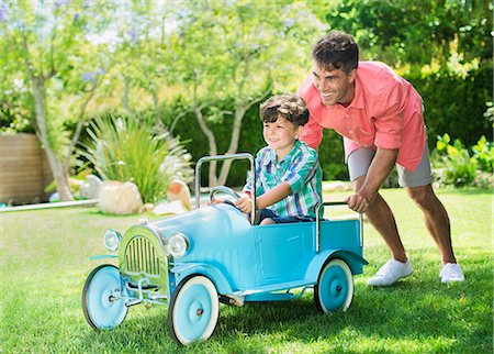 dad kid drive car - Father and son playing in backyard Stock Photo - Premium Royalty-Free, Code: 6113-07159749