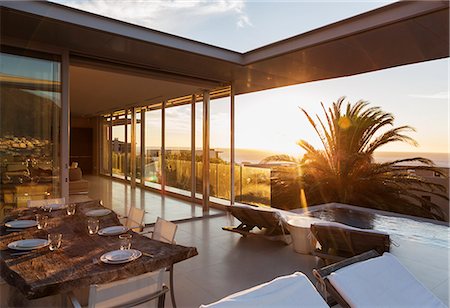 simsearch:6113-07648946,k - Patio overlooking swimming pool and ocean at sunset Photographie de stock - Premium Libres de Droits, Code: 6113-07159767