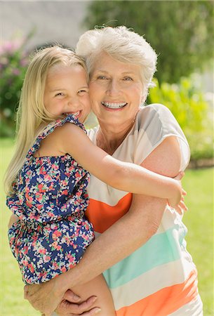 simsearch:6113-07159537,k - Older woman holding granddaughter in backyard Stock Photo - Premium Royalty-Free, Code: 6113-07159705