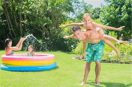 fun and splash and adults - Father and daughter playing in backyard Stock Photo - Premium Royalty-Free, Code: 6113-07159723