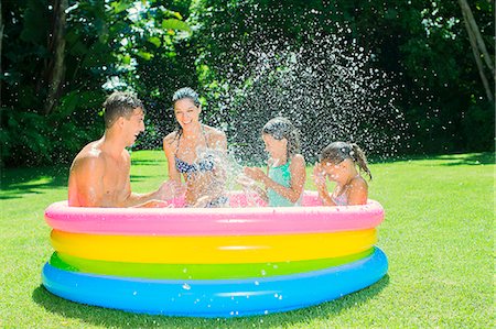 sitting by the pool - Family playing together in wading pool Foto de stock - Sin royalties Premium, Código: 6113-07159725