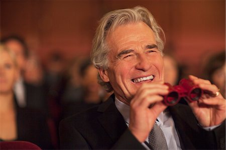 Man with opera glasses laughing in theater audience Foto de stock - Sin royalties Premium, Código: 6113-07159882