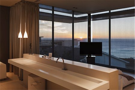 Modern sink in bedroom overlooking ocean at sunset Foto de stock - Sin royalties Premium, Código: 6113-07159829