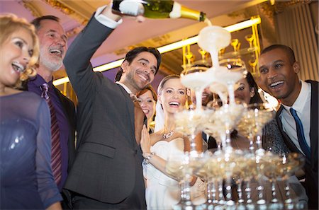 Groom pouring champagne pyramid at wedding reception Stock Photo - Premium Royalty-Free, Code: 6113-07159954