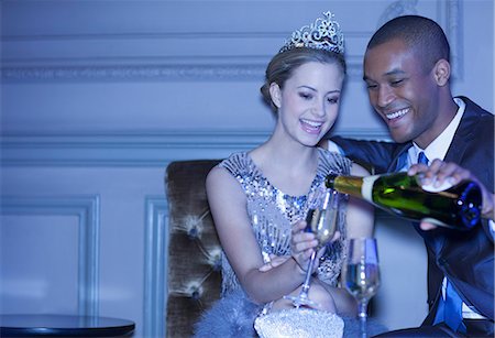 party in lounge - Man pouring champagne for woman in tiara Stock Photo - Premium Royalty-Free, Code: 6113-07159965