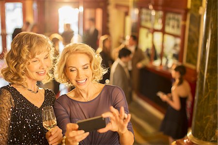 dramatic arts - Well dressed women looking at cell phone in theater lobby Stock Photo - Premium Royalty-Free, Code: 6113-07159930